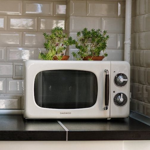 silver microwave oven on white wooden cabinet