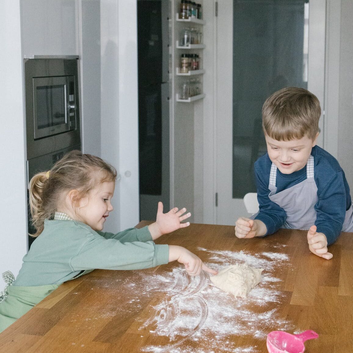 kids playing flour on the kitchen