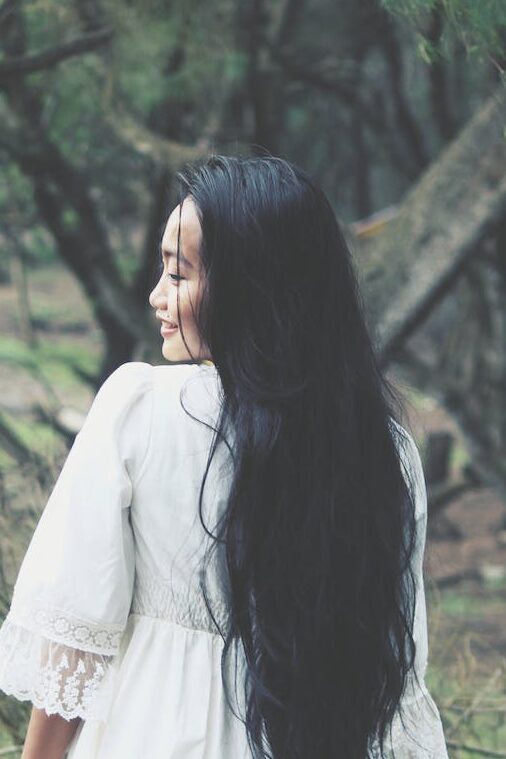 shallow focus photography of woman in white mini dress near tress